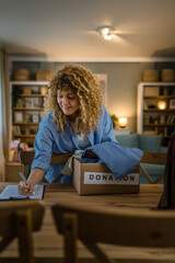 One young adult woman prepare wardrobe clothes for charity donation