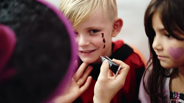 Group of kids having halloween make up on face at home