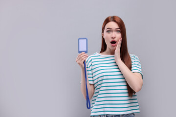 Naklejka premium Shocked woman with vip pass badge on light grey background. Space for text