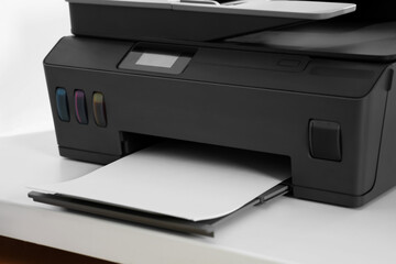 Modern printer with paper on white table, closeup