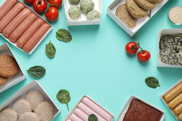 Flat lay composition with different vegan meat products and tomatoes on turquoise background. Space...