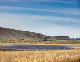 Dry grass, lake and cliff