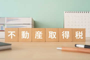 不動産取得税のイメージ｜木のブロックが置かれたデスク