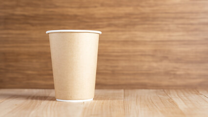 One eco-friendly cardboard cup on a wooden background. The concept of eco-friendly, purity. Mock-up. Copy space. - generative ai