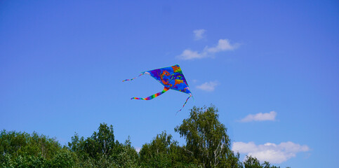 A kite flies in the blue sky