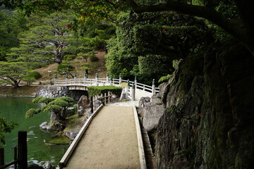 Traditional Bridge, Pond and Japanese Garden at Ritsurin Garden Park in Takamatsu, Kagawa, Japan -...