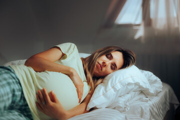 Pregnant Woman Sleeping in her Bedroom Resting in Bed. Mother to be relaxing and taking a nap at...