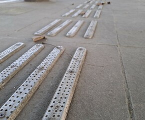 Fototapeta premium tactile warning strip for the visually impaired on the sidewalk. Tactile ground surface indicators for blind and visually impaired. Detectable warnings outside