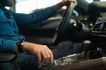 Close-up of a man's hand while shifting the automatic transmission of a car.