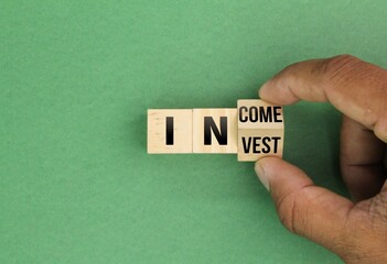 wooden cube with the words Invest or income. the concept of income through investment. Business and investment or income concept.