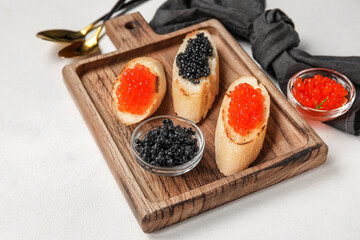 Tasty bruschettas with red and black caviar on white background