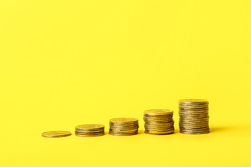 Stacks of coins on yellow background