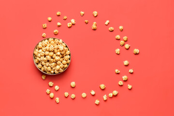 Bowl with crispy popcorn on red background