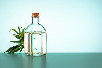  Cannabis leaves and bottle of hemp oil on the table. medical marijuana concept.