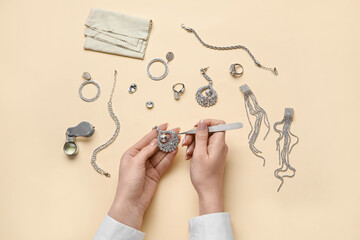Woman cleaning stylish accessories on color background