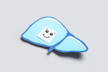 Blue paper liver with smiling face on grey background