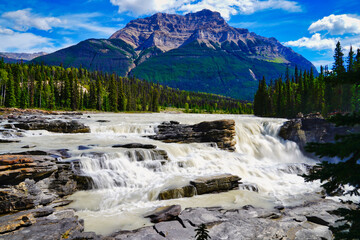 Fototapeta na wymiar Mount Edith Cavell at 3363 meters towers above the churning waters of the magnificient Athabasca falls near Jasper in the Canada Rockies