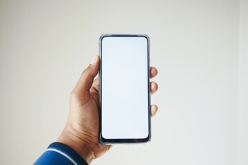 Close up of young man hand using smart phone with empty screen 