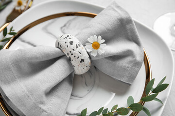 Plates with folded napkin and flowers on grunge white background