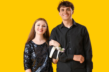 Beautiful prom couple on yellow background