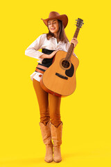Beautiful cowgirl with guitar on yellow background