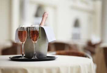 Restaurant, bottle and glasses of champagne on a table for luxury service, celebration and...