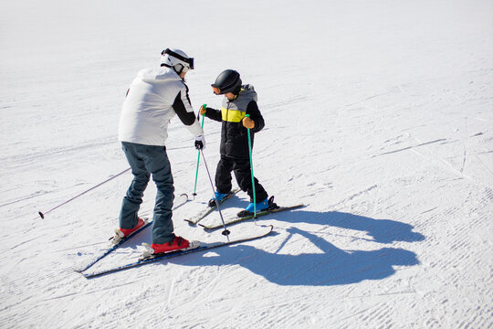Little boy learning how to ski with his coach