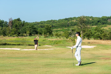 Golfer sport course golf ball fairway.  Group People lifestyle man and friend playing game golf tee off on the green grass. Asia men player game shot in summer