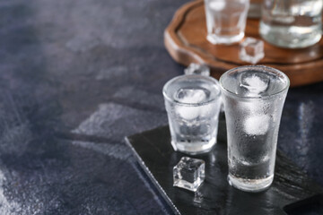 Boards with shots of vodka on dark table
