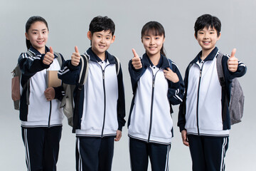 Studio shot of cheerful students doing thumbs-up