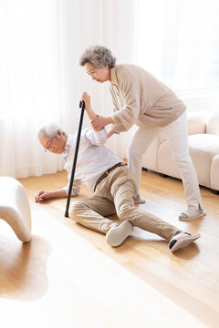 Senior woman helping her husband to get up