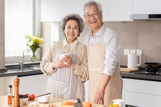 Cheerful senior couple cooking in kitchen