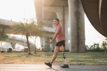 Woman wearing prosthetic equipment jogging in a park. Female walking and exercise works out outside.
