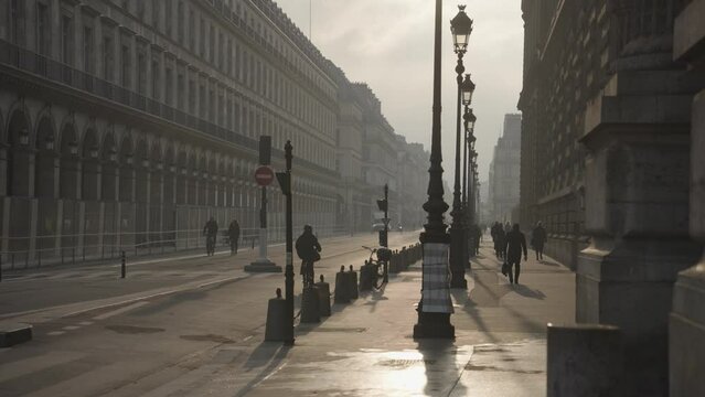 Paris, France - People Commute, Cars, Bike at Rue De Rivoli Street Morning Warm Sunrise