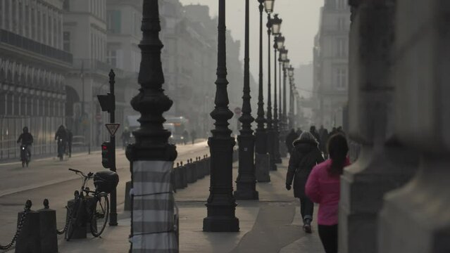 Paris, France - People Commute, Cars, Bike at Rue De Rivoli Street Morning Warm Sunrise