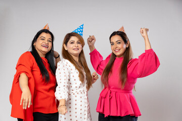 Indian women group wearing hat and giving happy expression together on white background.