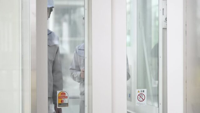 作業服姿で機器の点検をする作業員 エレベーターなどの映像 クローズアップ