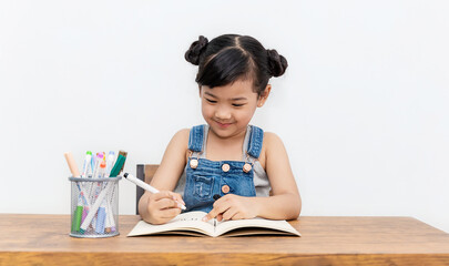 Portrait of little pupil writing at desk in classroom elementary school homework. Student girl study doing test in primary school. Children writing notes in classroom. Education knowledge concept