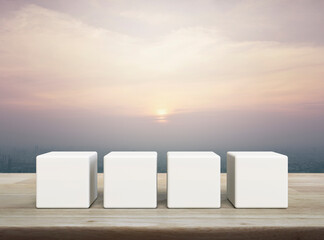 Four white block cubes on wooden table over modern city tower and skyscraper at sunset, vintage...