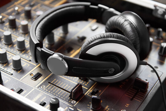 Headphones, mixer and sound engineering equipment in a recording studio for music production closeup. DJ, control and creative with audio technology from above to produce for radio broadcasting