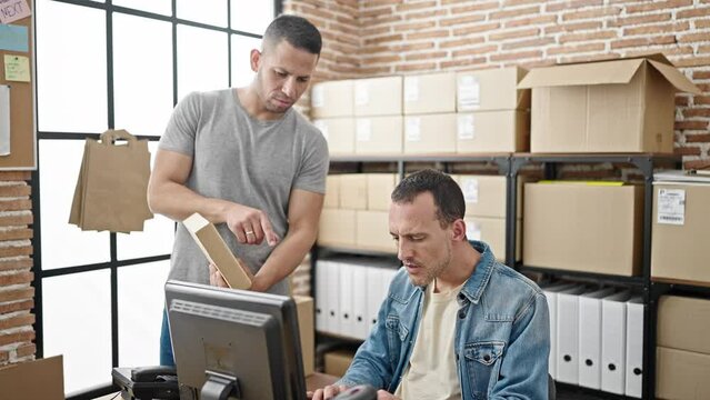 Two men ecommerce business workers using computer make photo to package at office