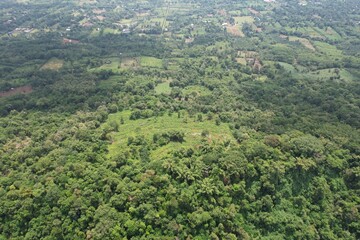 Fototapeta na wymiar A mesmerizing drone photo of mountain ranges displaying vast green plateaus and lush trees.