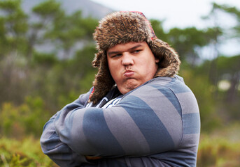 Angry, frustrated and young overweight man in nature during winter unhappy, grumpy and sad due to...