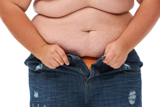 Weight gain, plus size and jeans of a person with overweight and stomach issue in studio. White background, model and casual fashion too tight from stomach and waist wellness problem of pants