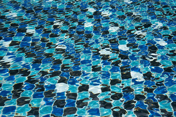 Fototapeta premium Water surface with waves on water surface wave effect You can see the blue square tiles at the bottom of the pool. 
