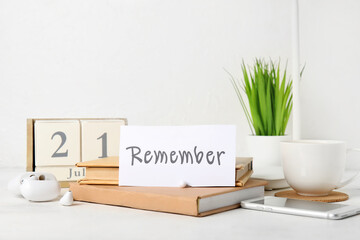 Reminder with books, mobile phone and earphones on white table
