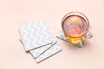 Drink coasters with cup of tea on beige table © Pixel-Shot