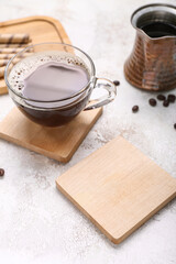 Drink coasters with cup of coffee and jezve on grey grunge table