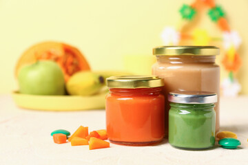 Jars of healthy baby puree on color background