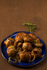 Fried mushrooms champignons with rosemary on a plate